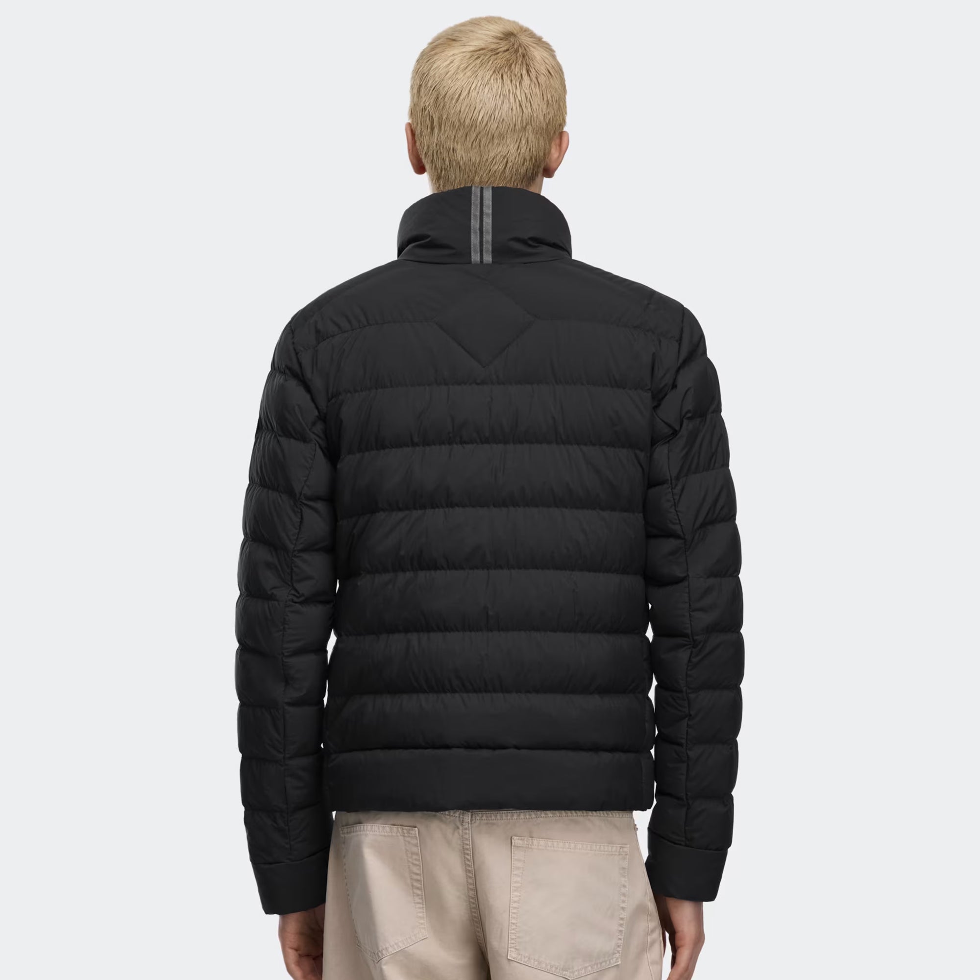 person wearing a black jacket on a white background