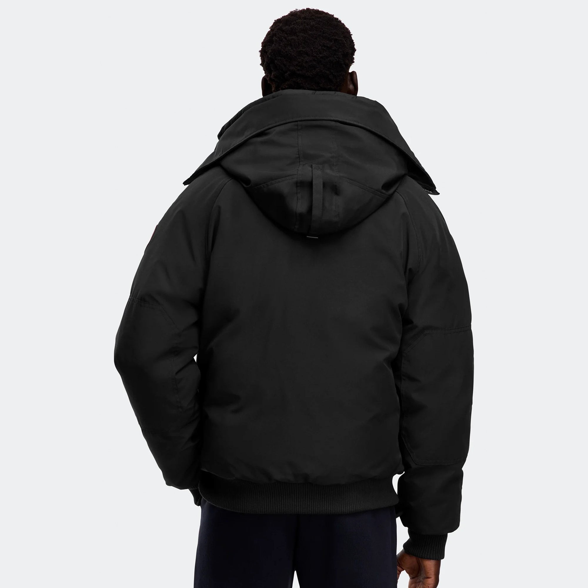 person wearing a black jacket on a white background
