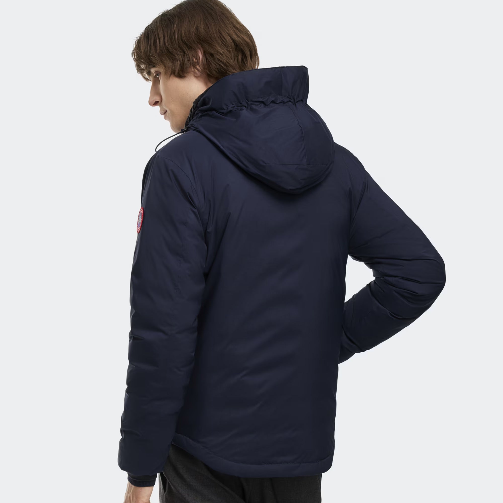 person wearing a navy and black jacket on a white background