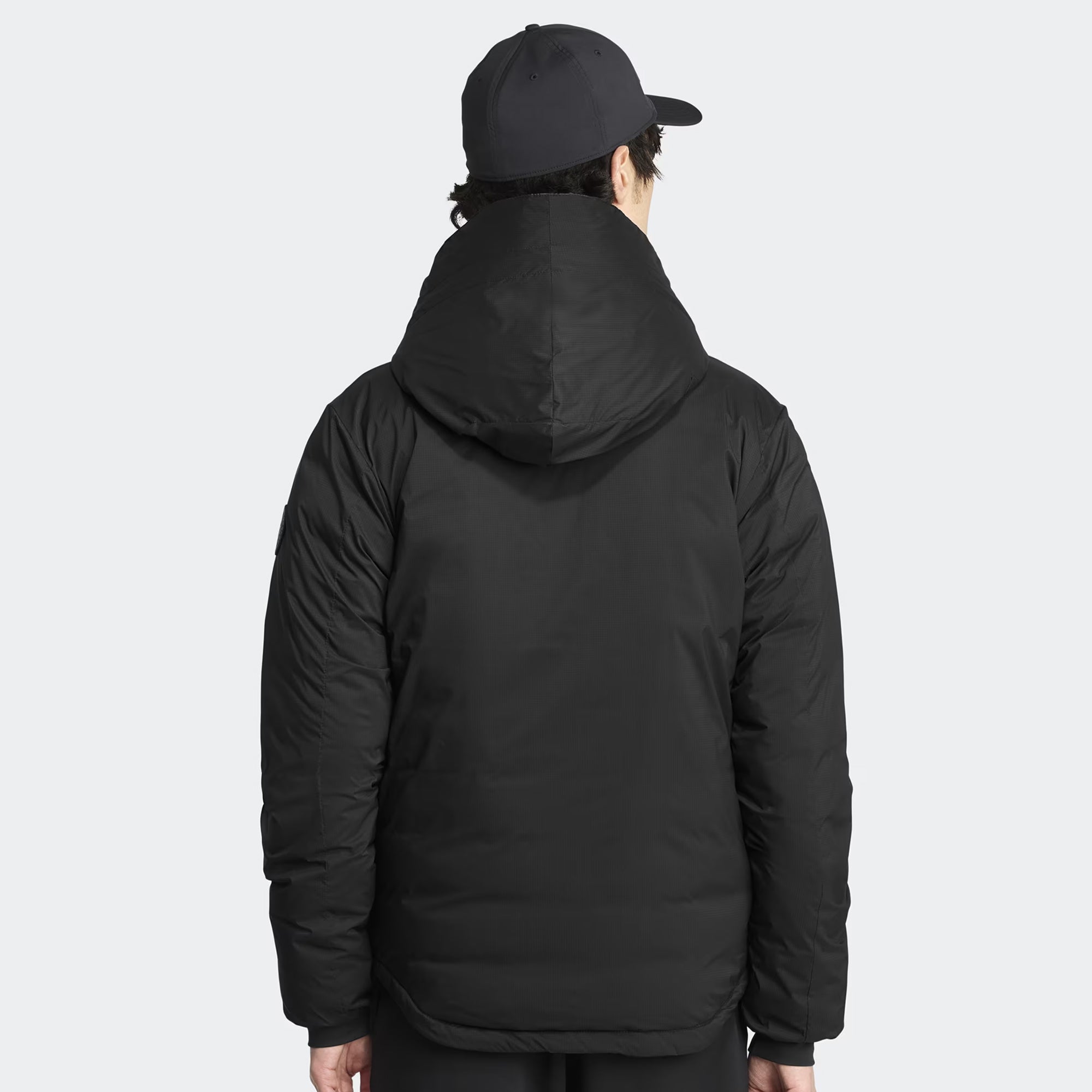 person wearing a black jacket on a white background