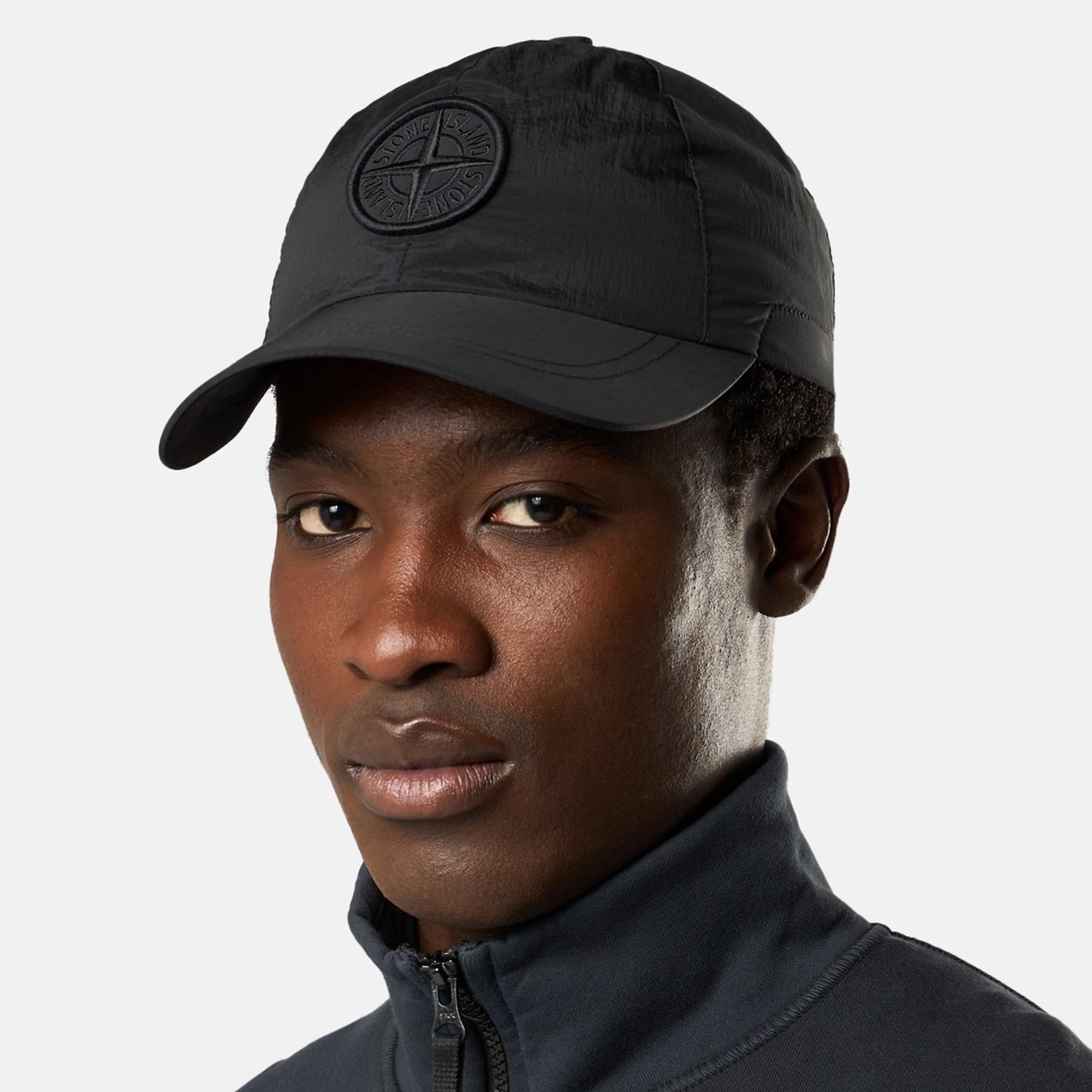 person wearing a black nylon hat on a white background