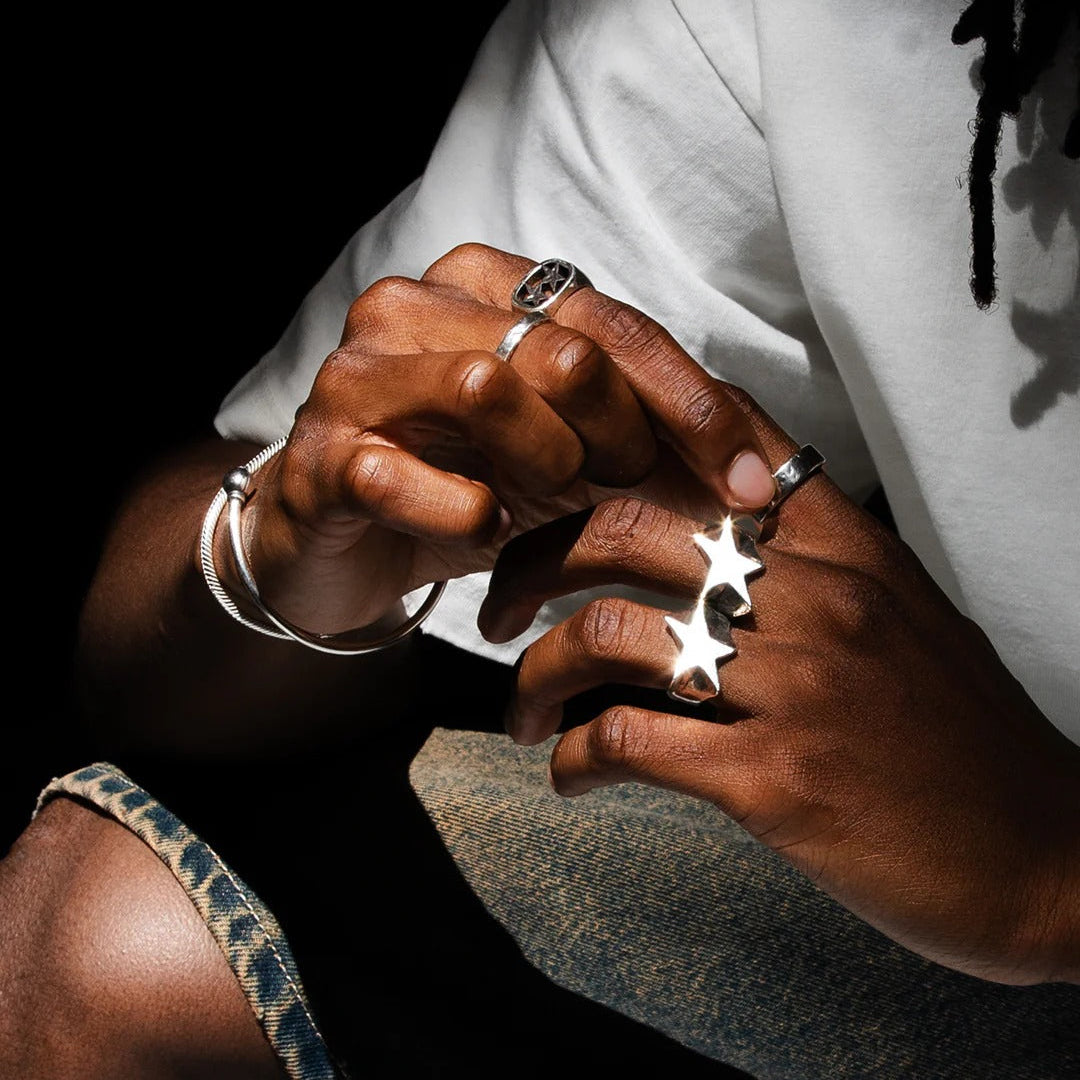 Close-up of hands with rings and bracelets on a dark background